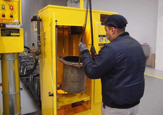 Der Komatsu-Techniker setzt das Filterelement in den Brennofen ein. Dort wird es mehrere Stunden lang bei 800 Grad „gebacken“, das heißt, sämtliche Rußreste werden zu Asche verbrannt. | Foto: Komatsu