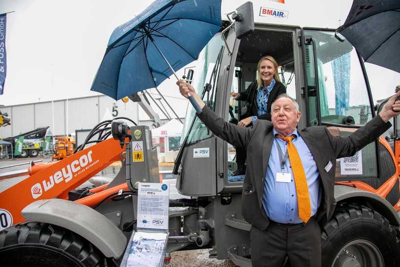 Einen Regenschirm braucht Ronald Figiel von der Van-der-Wehl-Gruppe in diesem Jahr wohl nicht auf der Nordbau - Messebesucher können sich über das Spätsommerhoch freuen. | Foto: Nordbau/SixConcept