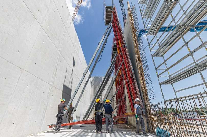 Mit nur einem Kranhub werden 26 m² Schalung umgesetzt, inklusive kompletter Schrägabstützung und Betonierbühne aus dem Konsolensystem MXK. | Foto: Andreas Tausend