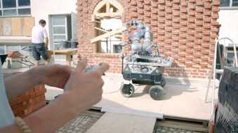 Roboter und Maurer bauen klimaoptimierte Wände