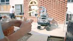 Roboter und Maurer bauen klimaoptimierte Wände