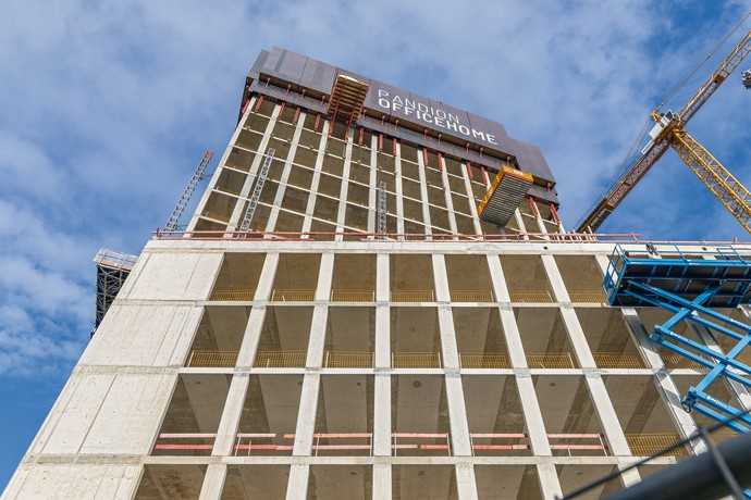 Windschild mit Werbeeffekt: Eine weithin sichtbare RCS Kletterschutzwand schützte und beschleunigte die Rohbauarbeiten in den jeweils obersten Geschossen. | Foto: Andreas Tausend