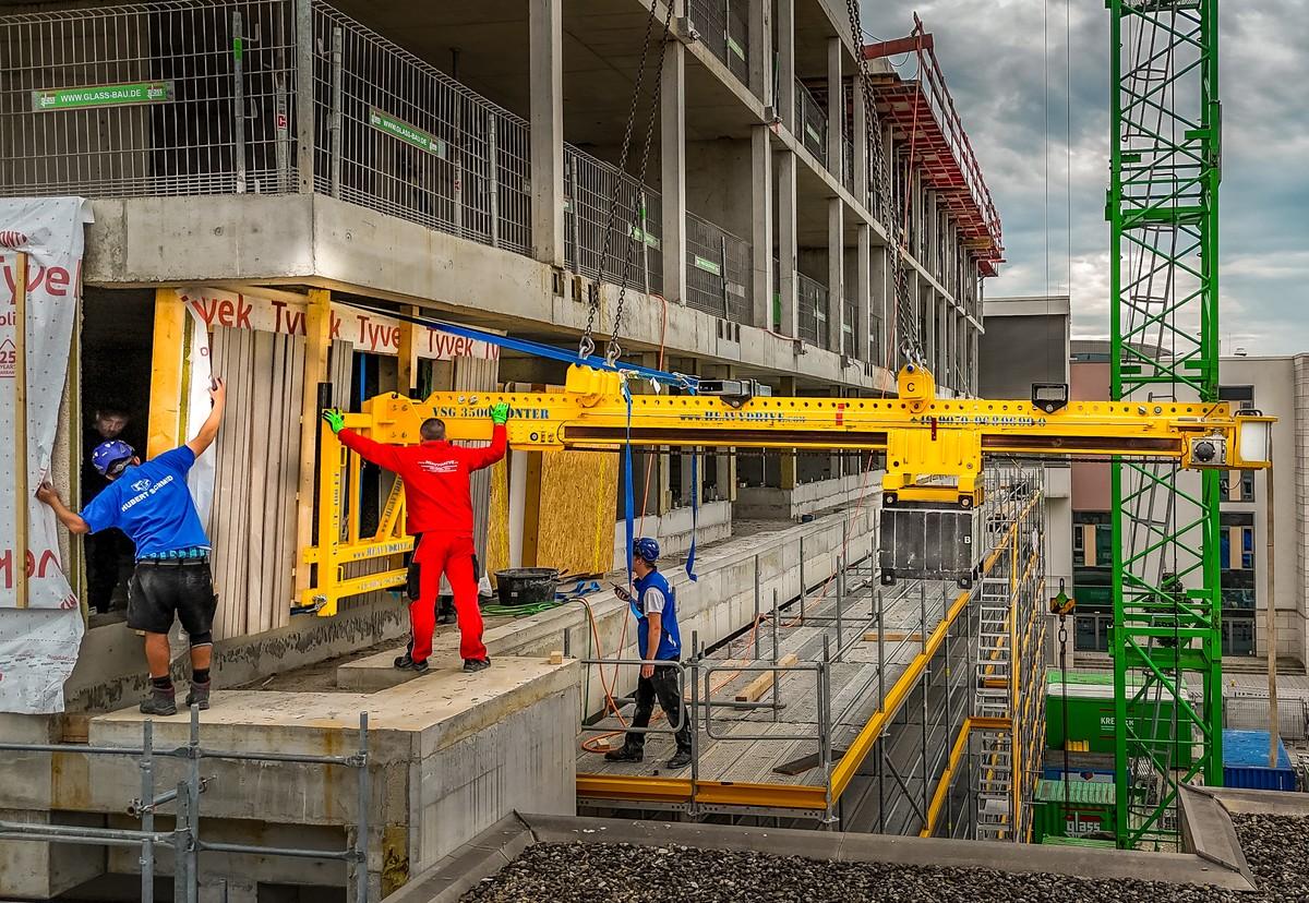 Mit der Kontertraverse und dem Gabeladapter lassen sich Holzwände bis zu 3,3 Meter tief in Laubengänge einheben. | Foto: Heavydrive.com