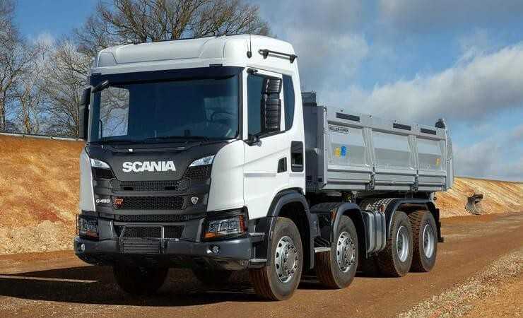 Vierachser Scania G 450 XT B8x4HZ mit D421-Dreiseitenkipper von Meiller und robuster XT-Front