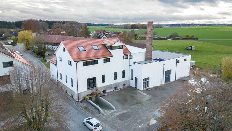 Das Bestandsgebäude dominiert die Architektur: Das Bindeglied schafft einen Übergang zwischen dem Satteldach und dem Flachdach des Hallenneubaus. | Foto: Xella Deutschland / Holger Krull