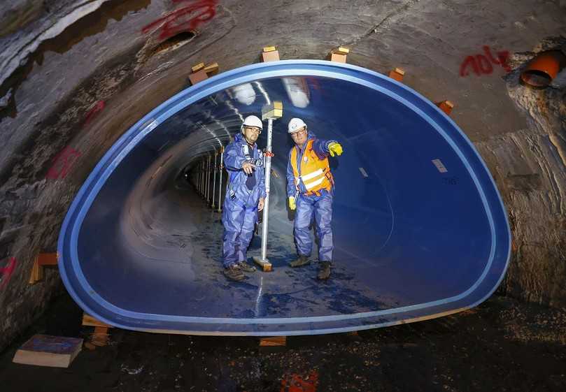 Die GFK-Rohre werden mit Hilfe von Ziegelsteinen und Holzkeilen in ihrer Lage gesichert. Die Baustützen verhindern ein Aufwölben des Sohlbereiches während der Ringraumverdämmung. Im Gespräch: Aarsleff Oberbauleiter Johannes Leewe (l.) und Güteschutz Prüfingenieur Guido Heidbrink (r.). | Foto: Güteschutz Kanalbau