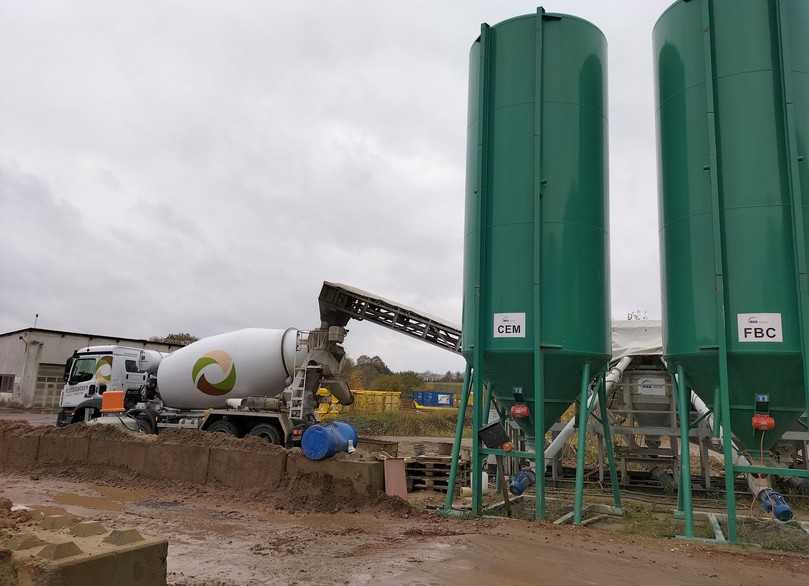 Semimobile Kompaktanlage auf dem Gelände in Grevenkrug. Hier wird der Trommelmischer gerade wieder mit Flüssigboden-Zutaten gefüttert. Die grünen Silos für Zement und Compound haben ein Fassungsvolumen von jeweils 33 cm3. | Foto: B_I/Valdix