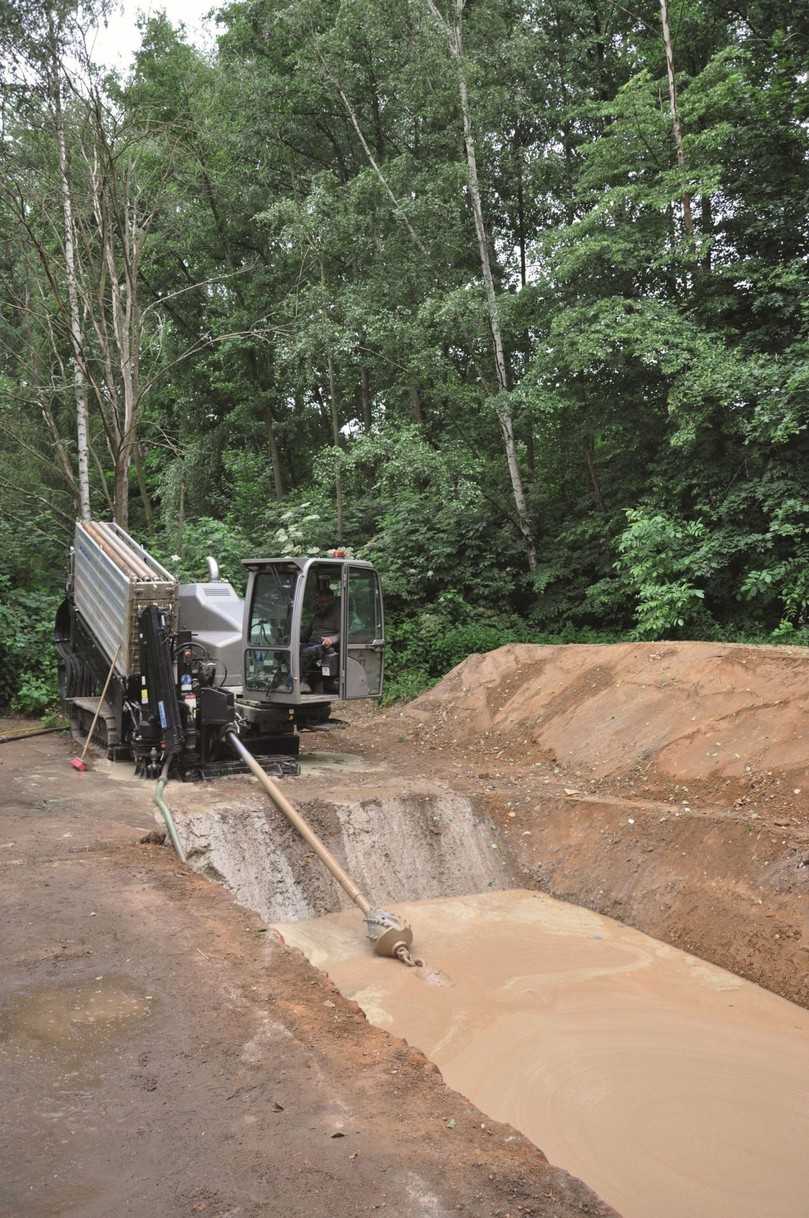 Die fertig verlegte neue Wasserleitung in der Zielgrube am anderen Flussufer. Gut zu sehen sind die verschiedenen Bodenschichten unterschiedlicher Festigkeit. Außerdem wird deutlich, welch geringe Fläche bei grabenlosem Bauen geöffnet werden muss. | Foto: Tracto-Technik