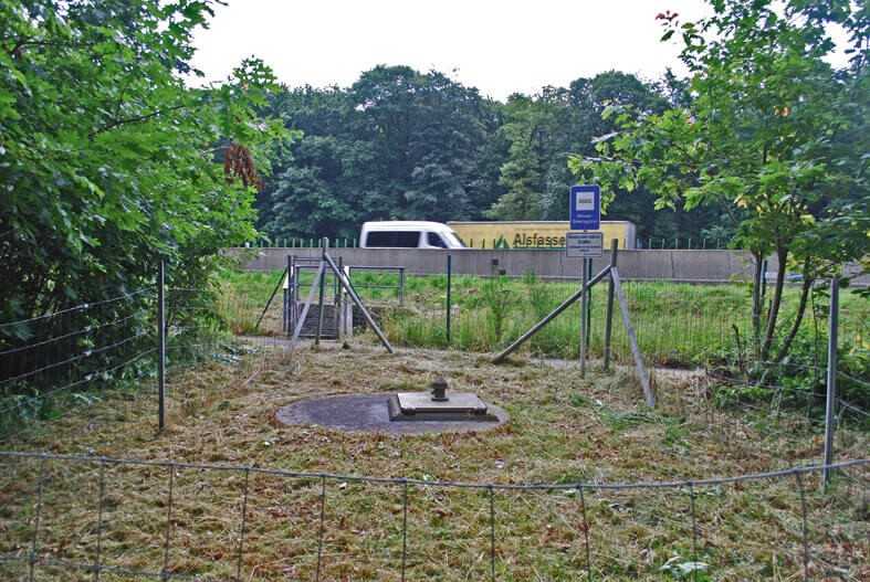 Trinkwasserbrunnen neben der Autobahn. Im Hintergrund der fließende Verkehr.