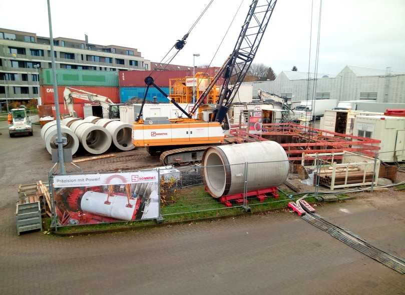 Abb. 4: Überblick über die Vortriebsbaustelle, im Bildhintergrund: Lärmschutzwand aus gestapelten Überseecontainern vor der angrenzenden Wohnbebauung | Foto: De la Motte