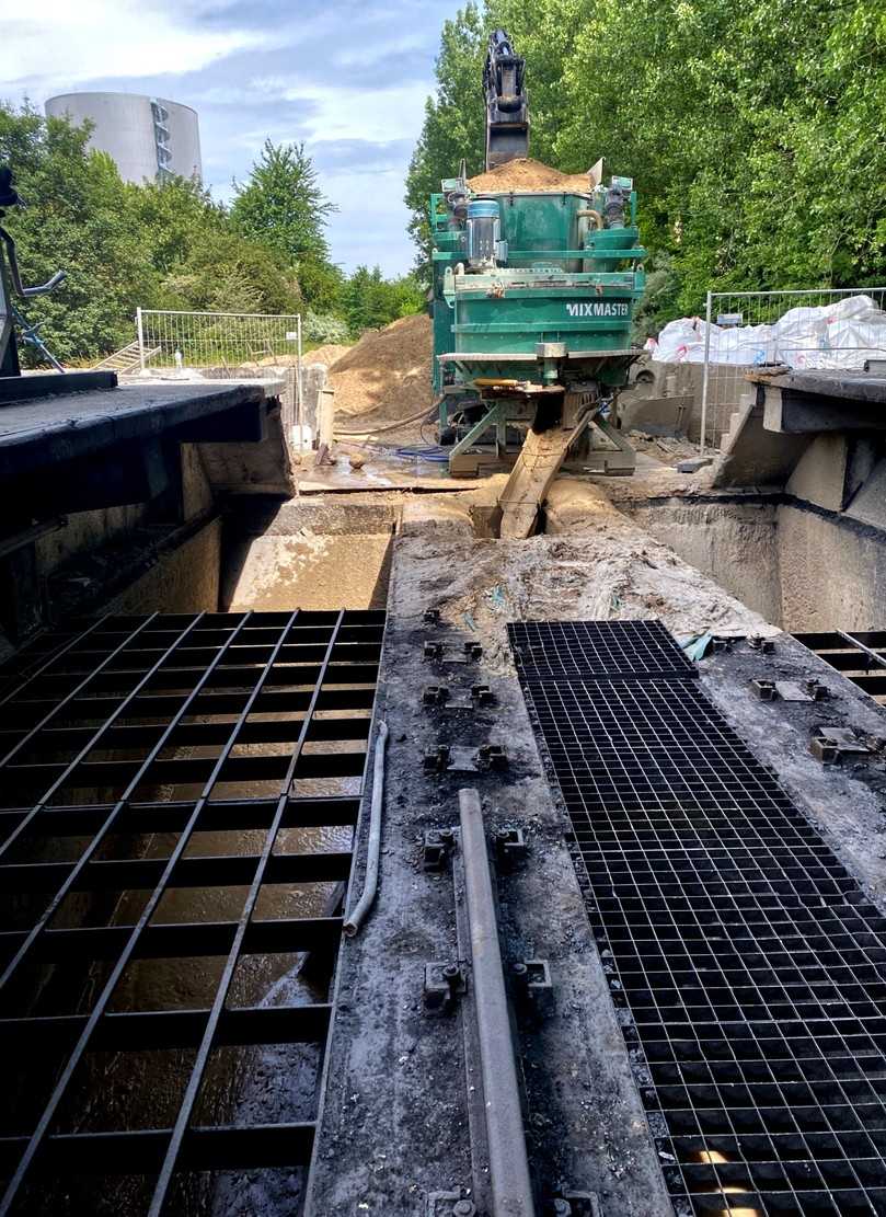 Der am Kopfende stehende, höhenverstellbare Bagger belädt die mobile Mischanlage mit dem Grundmaterial. Nach einer angepassten Mischzeit wird das Material als Flüssigboden in den aufzugebenden Bunker entlassen. | Foto: Flüssigboden SH