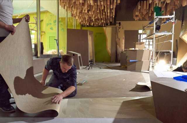 Bauarbeiten im Besucherbereich des Affenhauses: Die Furnierstreifen wurden einzeln an die Decke gehängt (hinten rechts). Wollen Mensch und Tier sich etwas näherkommen, gibt es dafür einen „Begegnungstunnel“ (hinten im Bild).