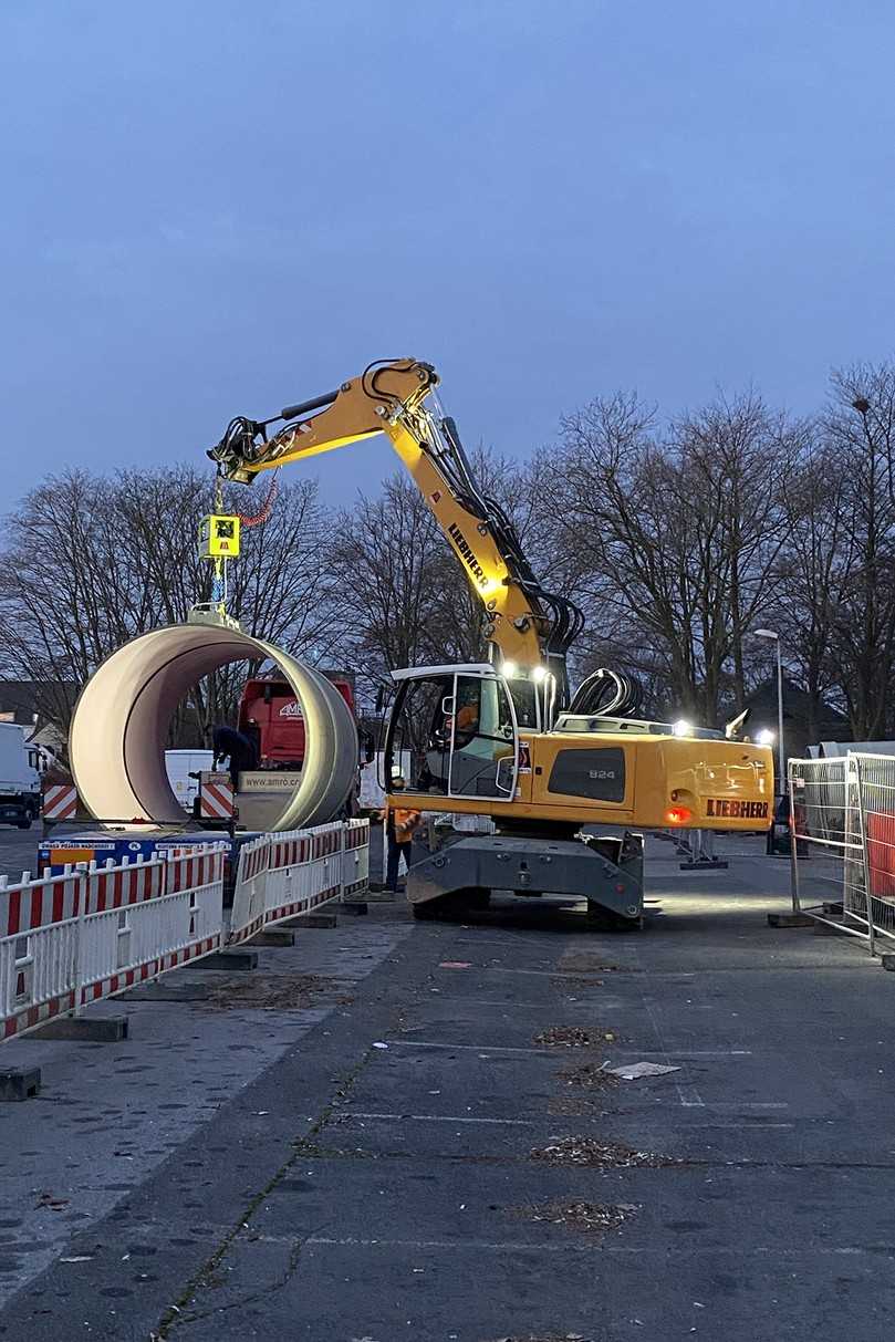 Mit einem von Stewering eingesetzten Anbaugerät, dass über eine Vakuumhebetechnik verfügt, werden die Rohre an der Einbaustelle angehoben und transportiert. | Foto: Klaus Stewering