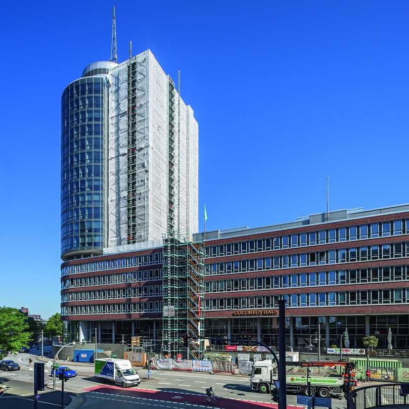 Das 77 m hohe Columbus Haus mit seinem Rundturm in der Hamburger HafenCity: Hinter dem weißen Staubschutz verbirgt sich eine gerüsttechnische Herausforderung. | Foto: Peri