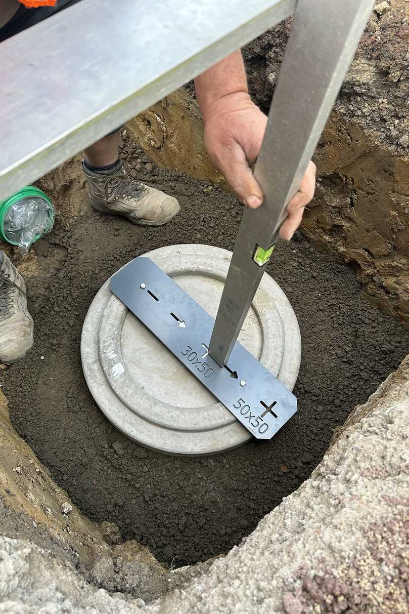 Unter den fachkundigen Augen des Funke-Anwendungstechnikers Thomas Bröer richtet ein Mitarbeiter der ausführenden Werner Pieper Straßenbau GmbH die Grundplatte mithilfe der mitgelieferten Positionsscheibe aus. | Foto: Funke Kunststoffe