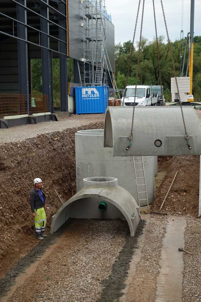 Montage der Betonfertigteile zu einem unterirdischen Sickertunnel. Im Hintergrund der Substratfilterschacht, der neben mineralölhaltigen Kohlenwasserstoffen auch Feststoffe wie Reifenabrieb und die Schwermetalle Kupfer und Zink aus dem Wasser entfernen kann. | Foto: Klaus W. König