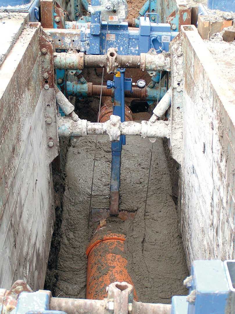 Einbau in Flüssigboden, der das Rohr nahtlos umschließt. Nach der eigenständigen Verfestigung gibt es kein Nachsacken des Bodens; spätere Straßeneinbrüche sind ausgeschlossen. | Foto: RAL Gütegemeinschaft Flüssigboden e.V.