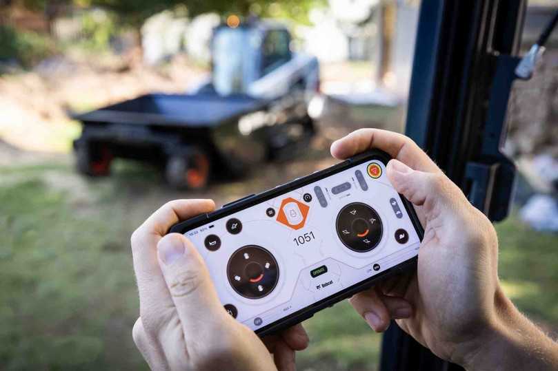 Bobcat fahren via Smartphone: Muss der Fahrer bei bestimmten Arbeiten ständig ein- und aussteigen, kann er auf die MaxControl-Fernsteuerung auf seinem Smartphone umschalten und den Lader bequem von außen bedienen. | Foto: Bobcat