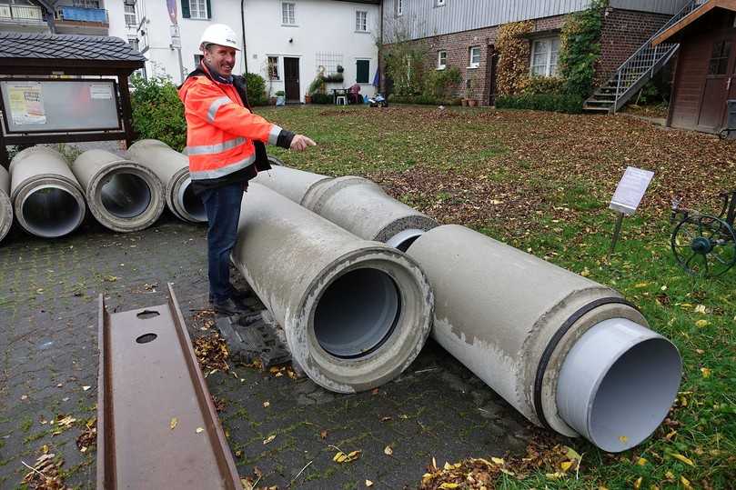 Die Fabekun-Rohre und -Schächte auf einer nahegelegenen Parkfläche zwischengelagert. Fasel-Fachberater Rüdiger Göbel weist auf das charakteristische Doppeldicht-System der Fabekun-Rohre hin. | Foto: Gebr. Fasel Betonwerk GmbH