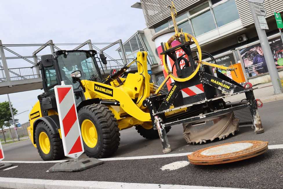 Haenlein erneuert Schachtabdeckungen mit Radlader und Fräse im Rekordtempo