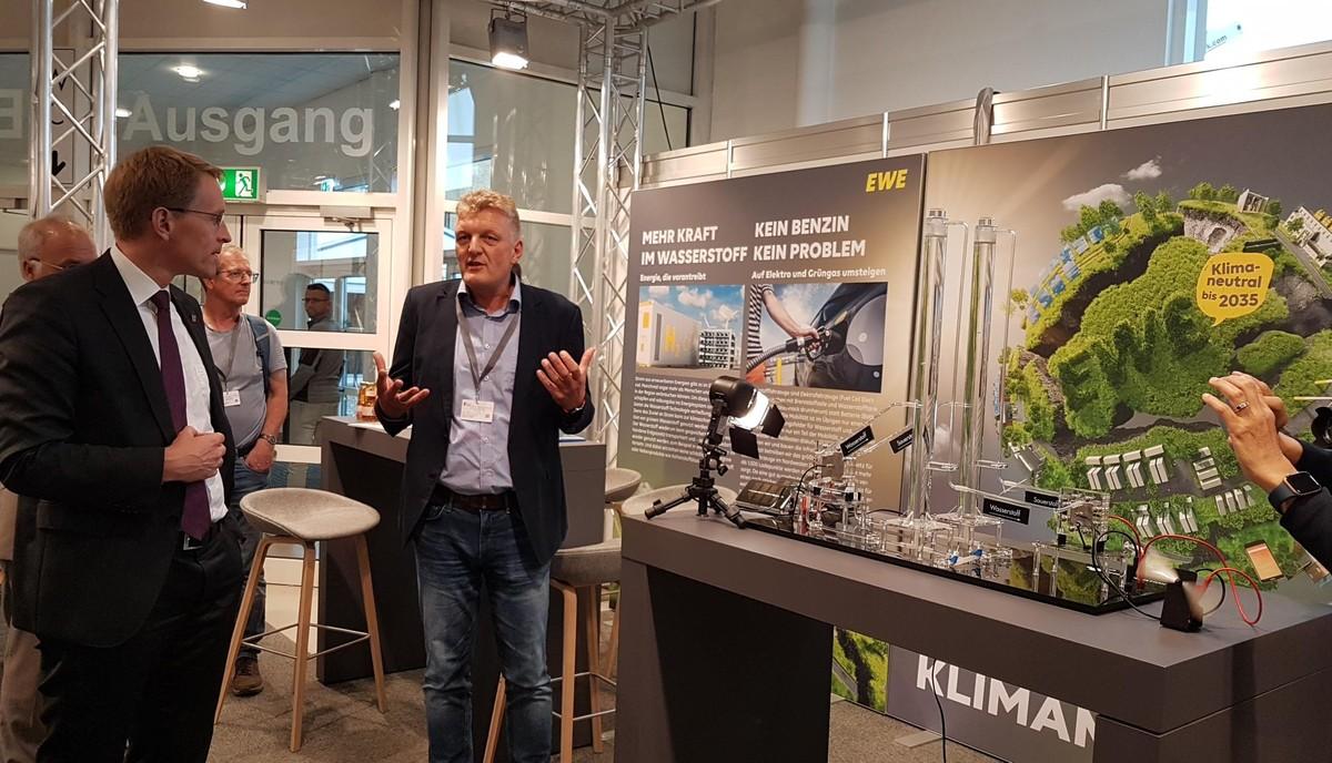 Ministerpräsident Daniel Günther lässt sich auf der Sonderschau in Halle 6 die Funktionsweise der Wasserstofftechnologie erläutern. | Foto: bb