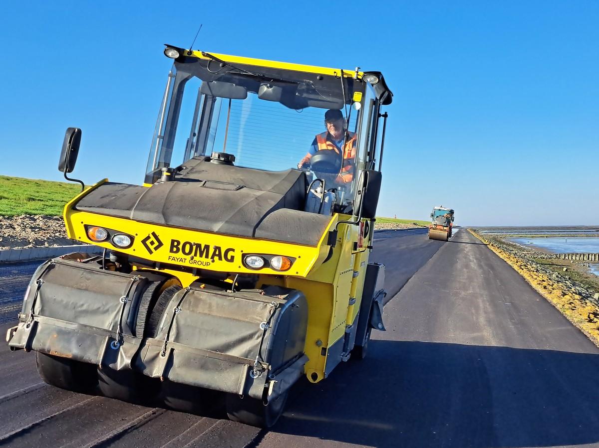 Hinter dem Asphaltfertiger sorgt eine BOMAG Gummiradwalze BW 28 RH für die Verdichtung; eine Hamm DV 70 fährt mit einigem Abstand zum Glätten hinterher. | Foto: DAV/Quillmann